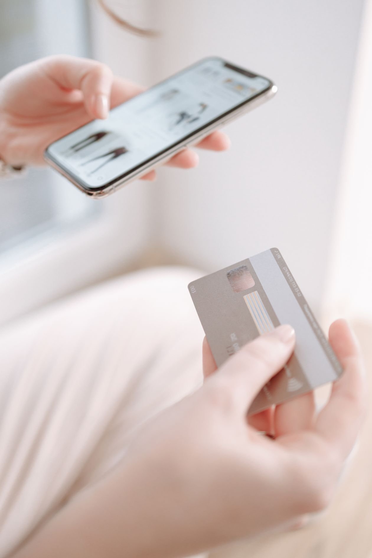 Hand holding a bank card and phone to manage loan repayments
