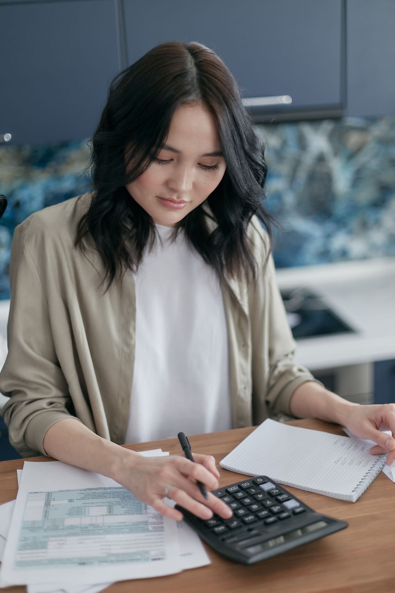 Woman using a calculator to work out a monthly budget and household bills