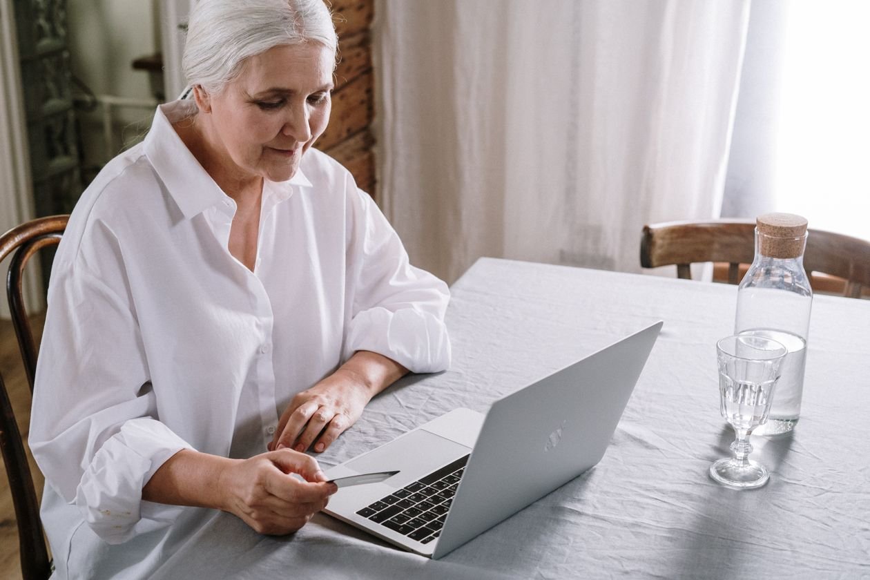 Older woman using a laptop at home to manage online payments and repayments