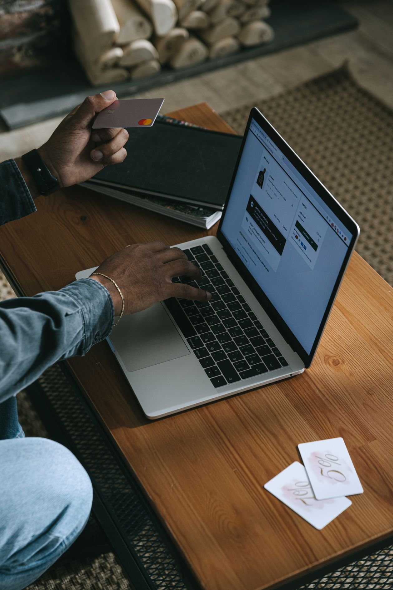 Person holding a credit card while using a laptop to manage a Zempler credit card account online